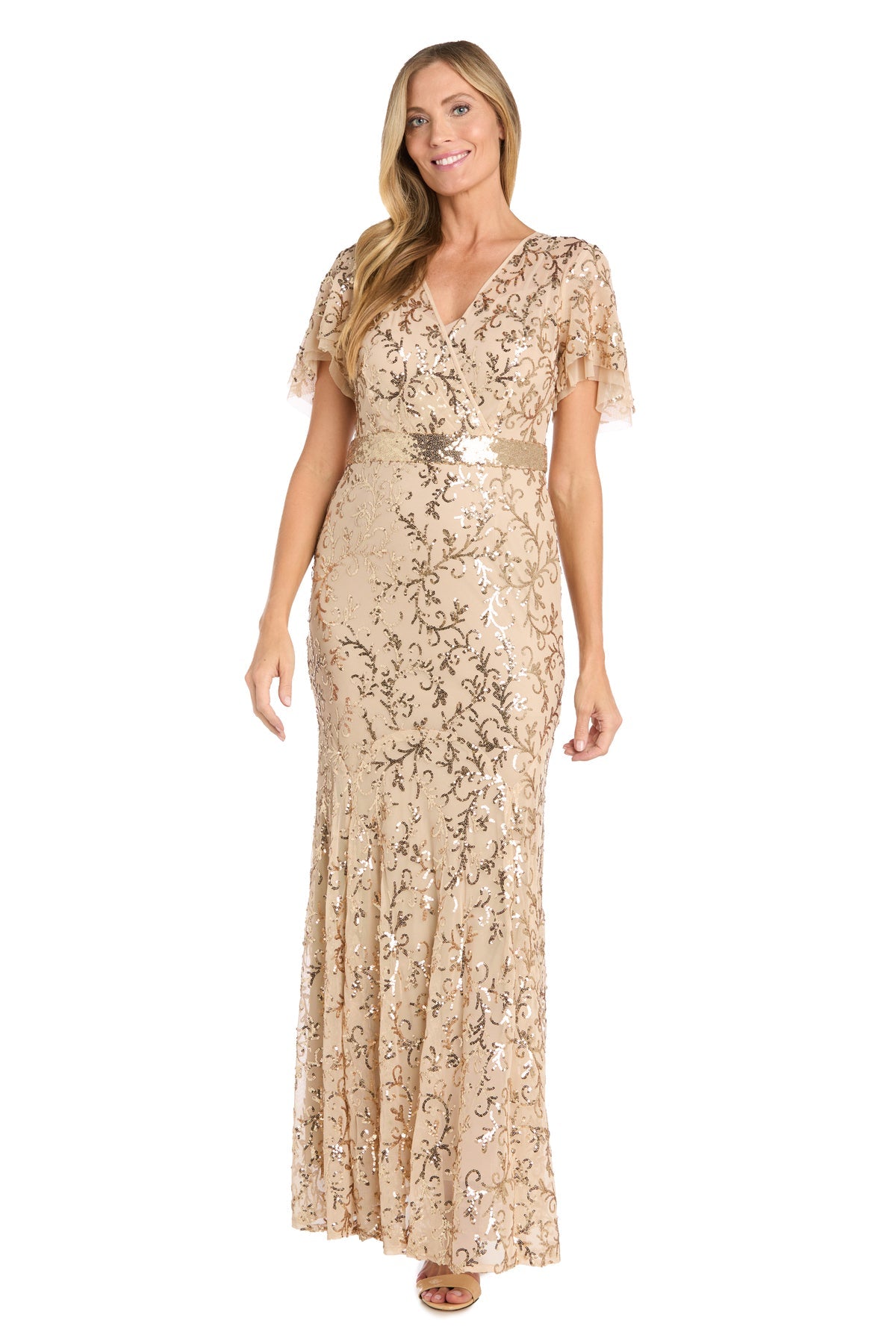 A woman stands smiling against a white background in the Long Gold Sequin Formal Dress: R&M Richards 3425, featuring floor-length style, short sleeves, and a V-neckline—an elegant choice for special occasions.